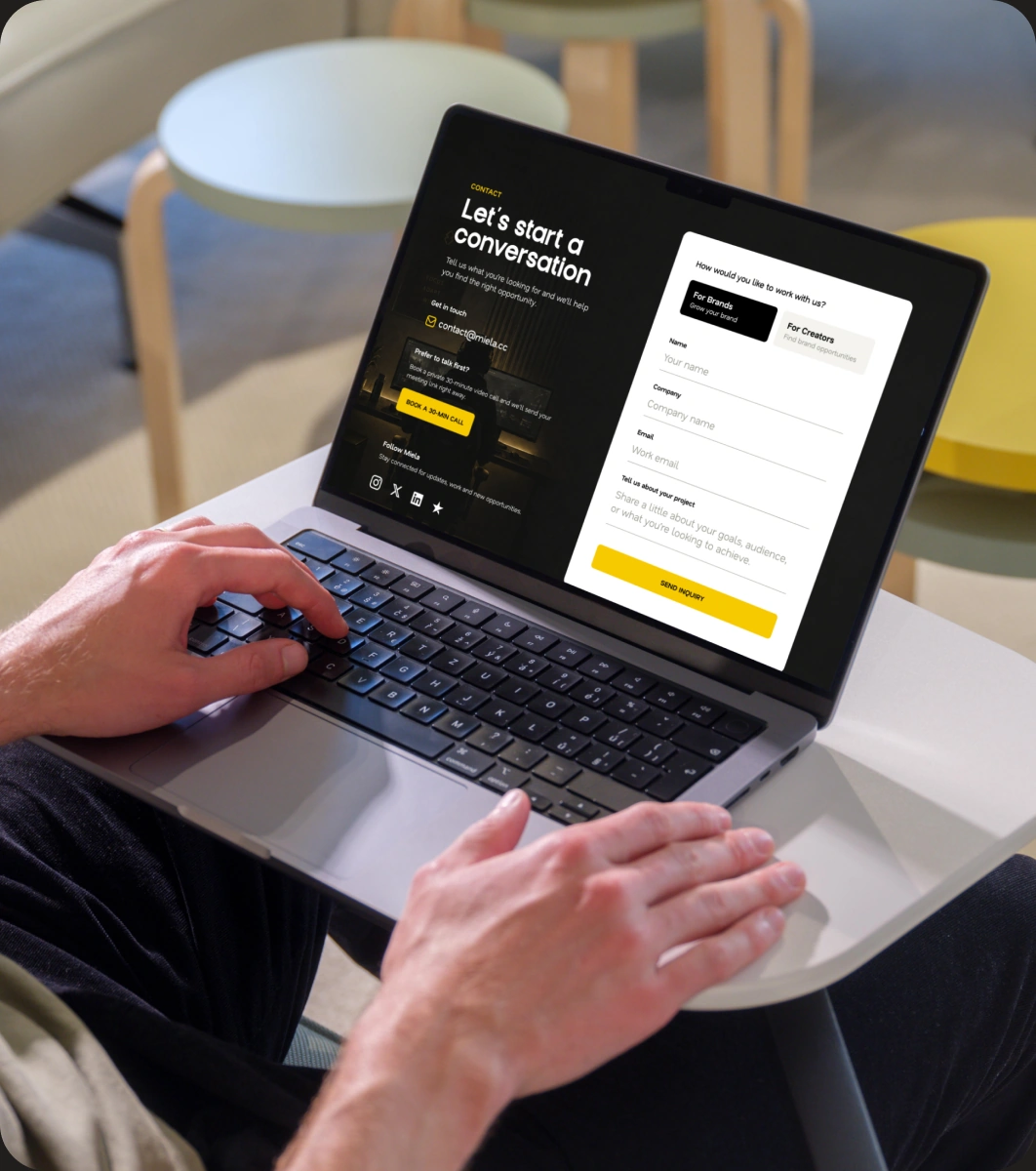 Miela website displayed on a laptop in a casual workspace